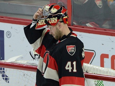 Ottawa Senators' Craig Anderson pulls his helmet on after letting in a third goal, prior to being replaced by goaltender Andrew Hammond during first period NHL action.