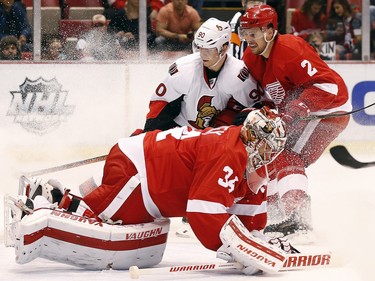 Detroit Red Wings goalie Petr Mrazek (34) stops the puck as Ottawa Senators right wing Alex Chiasson (90) is defended by Brendan Smith (2) in the first period.