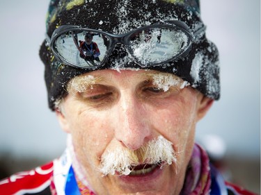 Ed Cottell is reflected in Chris Beattie's icy glasses at the finish line of the 27 km Classique race at the Gatineau Loppet.
