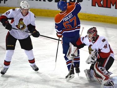 Edmonton Oilers Benoit Pouliot (67) tries to screen Ottawa Senators goalie Craig Anderson (41) with Dion Phaneuf (2) to the left.