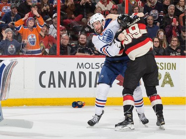 Eric Gryba #62 of the Edmonton Oilers fights with Max McCormick #89 of the Ottawa Senators during first period action.