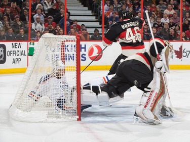 Zack Kassian #44 of the Edmonton Oilers crashes into the back of the net behind Andrew Hammond #30 of the Ottawa Senators during second period action.