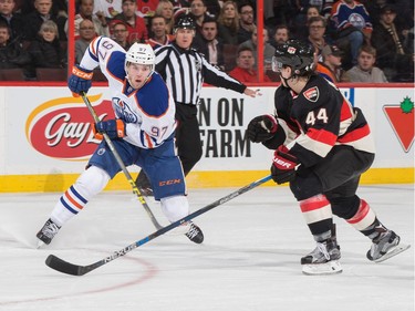 Connor McDavid #97 of the Edmonton Oilers controls the puck against Jean-Gabriel Pageau #44 of the Ottawa Senators.