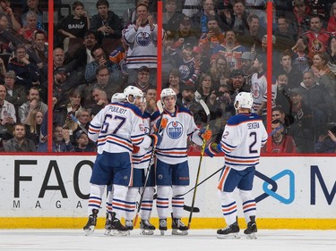 Benoit Pouliot #67, Connor McDavid #97 and Andrej Sekera #2 of the Edmonton Oilers celebrate the third of three first period goals.