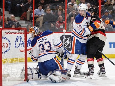 Cam Talbot #33 of the Edmonton Oilers watches the puck go over the goal line as teammate Justin Schultz #19 defends against Jean-Gabriel Pageau #44 of the Ottawa Senators.