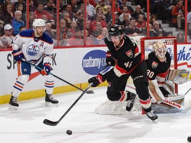 Patrick Wiercioch #46 of the Ottawa Senators skates with the puck as Taylor Hall #4 of the Edmonton Oilers and Andrew Hammond #30 of the Senators look on.