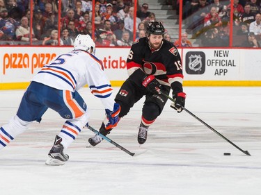 Zack Smith #15 of the Ottawa Senators stickhandles the puck against Mark Fayne #5 of the Edmonton Oilers.