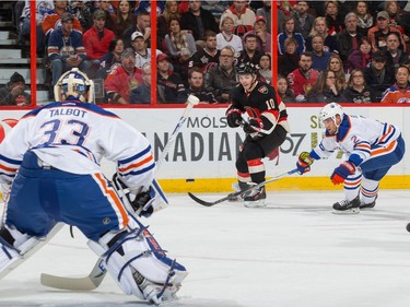 Shane Prince #10 of the Ottawa Senators sends a backhand shot against Cam Talbot #33 and Andrej Sekera #2 of the Edmonton Oilers.