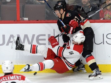 Carolina Hurricanes' Elias Lindholm gets pushed to the ice by Ottawa Senators' Justin Faulk during first period NHL action.