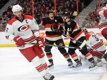 Carolina Hurricanes' Eric Staal, left, skates away as Ottawa Senators' Chris Neil and Jean-Gabriel Pageau (44) celebrate a goal by teammate Zack Smith, not shown, on Hurricanes goalie Eddie Lack (31) during second period NHL action.