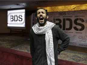 In this file photo, an Egyptian man shouts anti-Israeli slogans in front of banners with the Boycott, Divestment and Sanctions (BDS) logo.