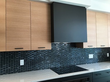 An integrated hood fan in matte black is one of the favourite elements of a European-style kitchen that designers Kelly Maiorino and Laurie Jarvis of Unique Spaces did at a Tartan model home in Poole Creek called the Bancroft. 'It creates a great focal point in this expansive kitchen,' Maiorino says.