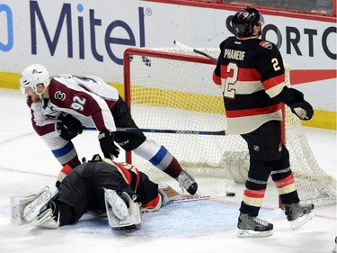 Colorado Avalanche's Gabriel Landeskog celebrates as he steps over Ottawa Senators goalie Andrew Hammond and new teammate Dion Phaneuf as they react to a goal during first period NHL action.