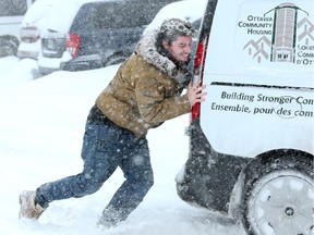 Jarren Miehm helps out an Ottawa Community Housing van stuck in a roadway off Ritchie Street.
