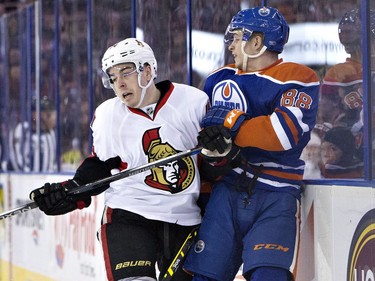 Ottawa Senators ' Jean-Gabriel Pageau (44) checks Edmonton Oilers' Brandon Davidson (88) during first period NHL action.
