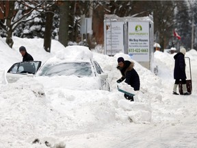 Jerome Jeffreys, left, helps his neighbour Evelynn Wong, right, dig her car out in the Glebe Wednesday February 17, 2016. (Darren Brown. Assignment 122921