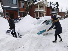 Jerome Jeffreys, left, helps his neighbour Evelynn Wong, right, dig her car out in the Glebe Wednesday February 17, 2016.