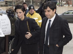 Jian Ghomeshi walks in front of protesters as he arrives at a Toronto courthouse with his lawyer Marie Henein (left) for the third day of his trial on Tuesday, Feb. 2, 2016.