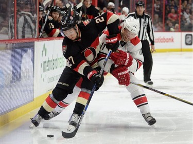 Carolina Hurricanes' Jordan Staal, right, fights to get the puck from Ottawa Senators' Curtis Lazar during second period NHL action.