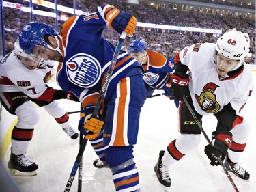 Ottawa Senators ' Kyle Turris (7) and Mike Hoffman (68) battle in the corner with Edmonton Oilers' Teddy Purcell (16) and Mark Fayne (5) during first period NHL action.