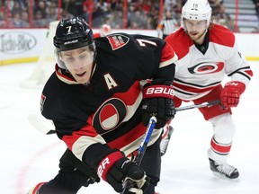 Kyle Turris of the Ottawa Senators battles against Elias Lindholm of the Carolina Hurricanes during first period NHL action.