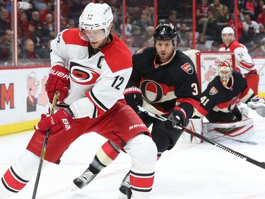 Marc Methot of the Ottawa Senators defends against Eric Staal of the Carolina Hurricanes during second period NHL action.