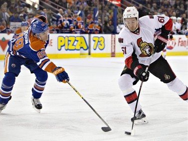 Ottawa Senators ' Mark Stone (61) is chased by Edmonton Oilers' Brandon Davidson (88) during first period NHL action.