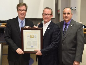 Mayor Jim Watson and Osgoode ward Coun. George Darouze present a Mayor's City Builder Award to Bruce Brayman.