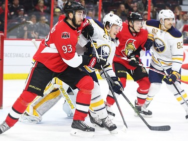 Mika Zibanejad, left,of the Ottawa Senators battles against Jake McCabe of the Buffalo Sabres as Ryan Dzingel battles against Marcus Foligno, right, during first period NHL action.