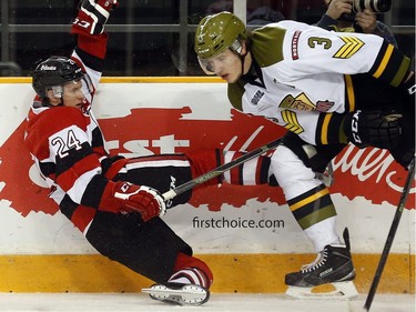 Ottawa 67s' Nevin Guy (24) is knocked to the ice by North Bay Battalion's Kyle Wood (3) during the first period.