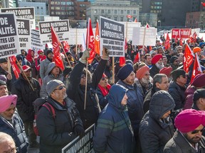 Taxi drivers from Toronto, Ottawa and Montreal take part in a rally on Parliament Hill Tuesday to call for regulations over Uber and other Internet ride services.