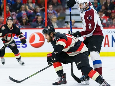 Ottawa Senators center Zack Smith (15) fights past the check of Colorado Avalanche defenseman Nick Holden (2).