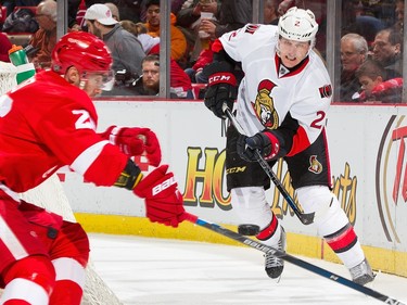 Dion Phaneuf #2 of the Ottawa Senators passes the puck past the stick of Tomas Jurco #26 of the Detroit Red Wings.