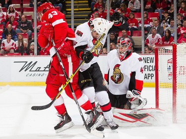 Darren Helm #43 of the Detroit Red Wings screens the view of Craig Anderson #41 of the Ottawa Senators with Cody Ceci #5 of the Senators.
