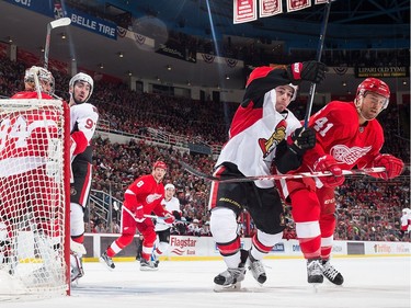 Petr Mrazek #34 of the Detroit Red Wings is screened by Mika Zibanejad #93 of the Ottawa Senators as Luke Glendening #41 of the Wings and Jean-Gabriel Pageau #44 of the Senators battle for position.