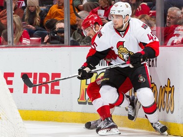 Chris Wideman #45 of the Ottawa Senators battles along the boards with Riley Sheahan #15 of the Detroit Red Wings.
