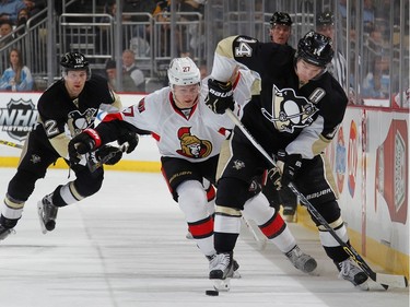 Chris Kunitz #14 of the Pittsburgh Penguins moves the puck up ice in front of Curtis Lazar #27 of the Ottawa Senators.