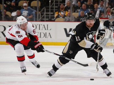 Phil Kessel #81 of the Pittsburgh Penguins moves the puck in front of the defense of Mark Stone #61 of the Ottawa Senators.