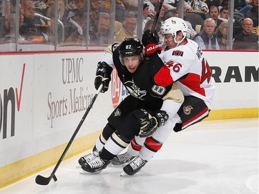 Sidney Crosby #87 of the Pittsburgh Penguins moves the puck in front of Patrick Wiercioch #46 of the Ottawa Senators.