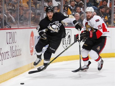 Kris Letang #58 of the Pittsburgh Penguins and Zack Smith #15 of the Ottawa Senators skate for the loose puck during the second period.