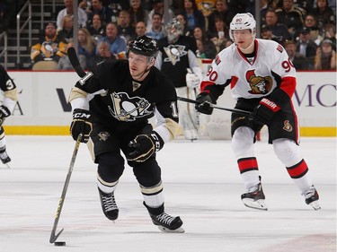 Kevin Porter #11 of the Pittsburgh Penguins moves the puck up ice in front of Alex Chiasson #90 of the Ottawa Senators.
