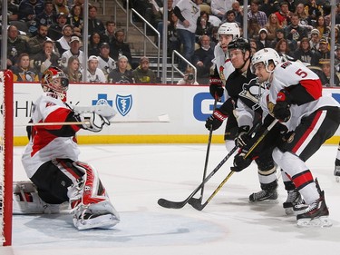 Craig Anderson #41 of the Ottawa Senators watches the loose puck while Jared Cowen #2 and Cody Ceci #5 of the Ottawa Senators battle for position against Patric Hornqvist #72 of the Pittsburgh Penguins.