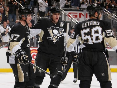 Sidney Crosby #87 of the Pittsburgh Penguins celebrates his second goal of the game with Evgeni Malkin #71 and Kris Letang #58 during the second period.