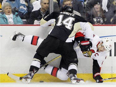 Chris Kunitz #14 of the Pittsburgh Penguins checks Erik Karlsson #65 of the Ottawa Senators.