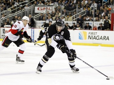 Evgeni Malkin #71 of the Pittsburgh Penguins handles the puck in front of Max McCormick #89 of the Ottawa Senators.