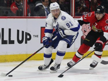 The Lightning’s Steven Stamkos tries to skate away from Senators Alex Chiasson during second period action.