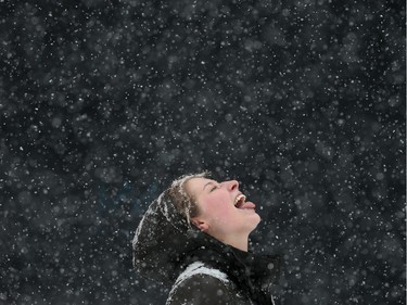 Heather Kirby stops to enjoy the snow on her way home from the gym Tuesday.  20-40 cm of snow is expected to fall by Tuesday night in Ottawa.