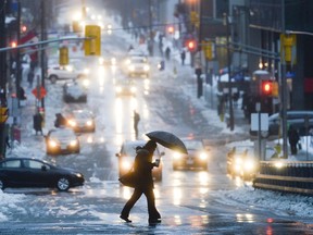 Pedestrians cross Metcalfe Street on a rainy Thursday morning.