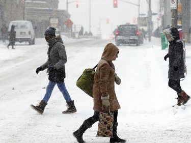 People commute through downtown Ottawa during a winter storm Tuesday February 16, 2016.