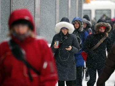 People commute through downtown Ottawa during a winter storm Tuesday February 16, 2016.